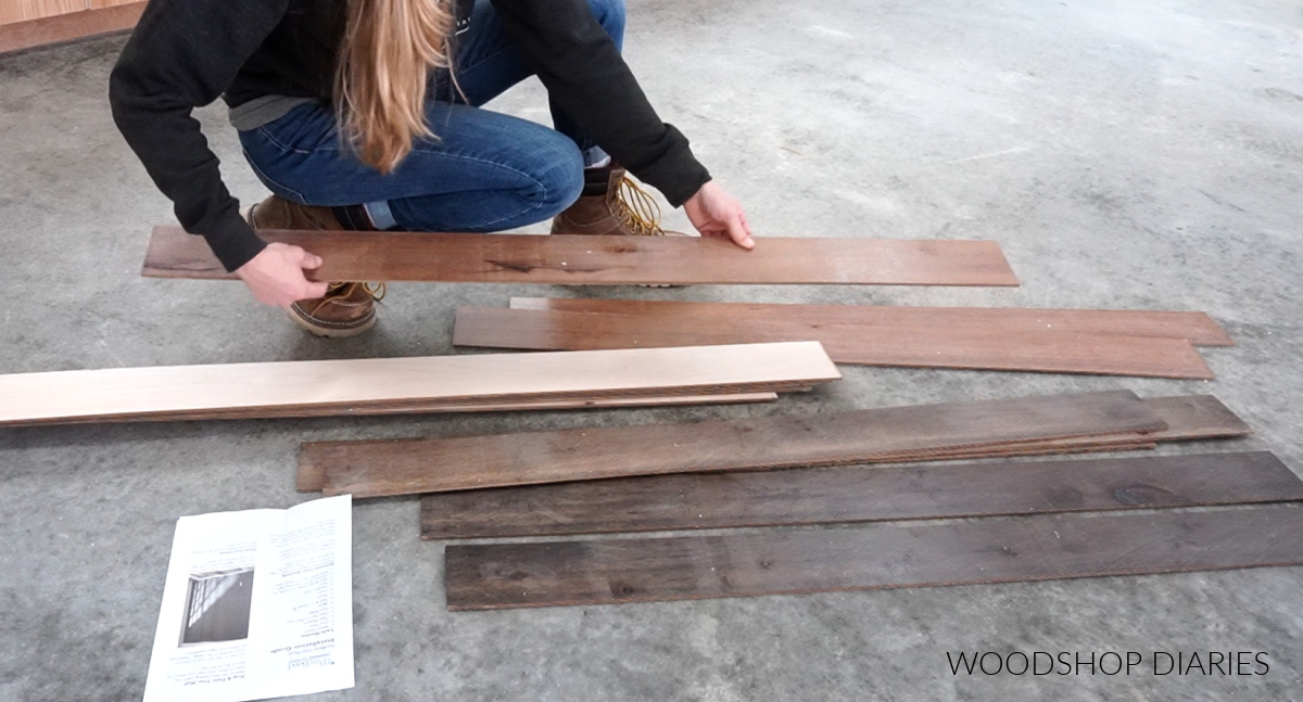 Shara Woodshop Diaries laying out plywood plank boards on workshop floor