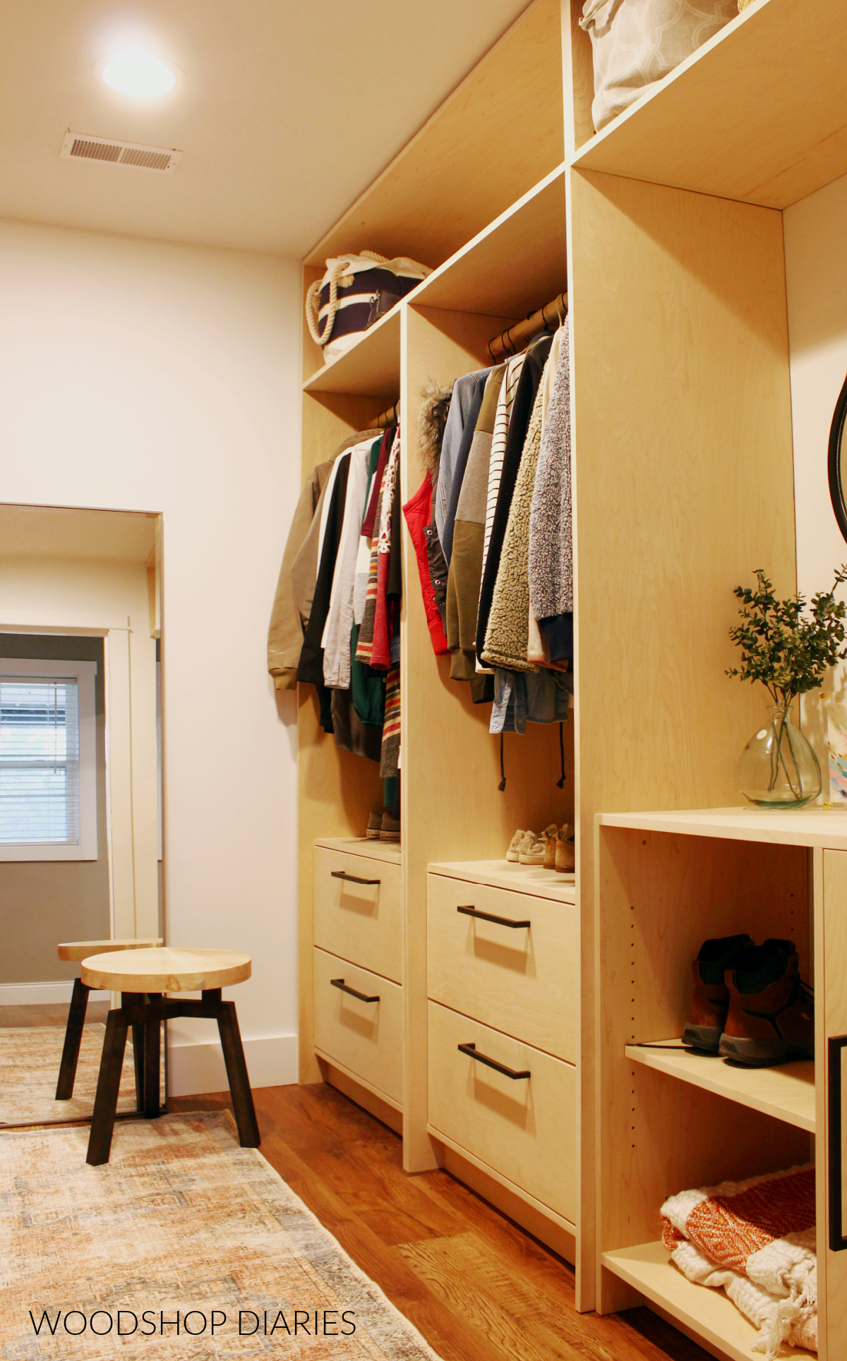 Completed closet built ins with clothes hanging, drawers, open cubbies and adjustable shelves