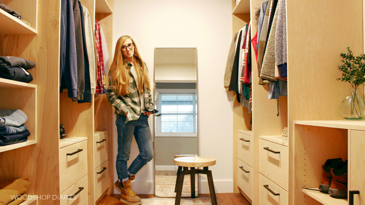 Shara Woodshop Diaries standing in walk in closet with built in cabinets on each side and mirror at back