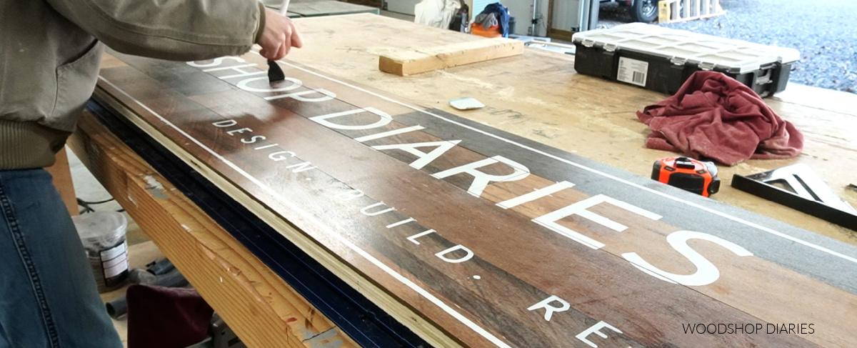 Removing vinyl stencil from lettering on Woodshop Diaries shop sign