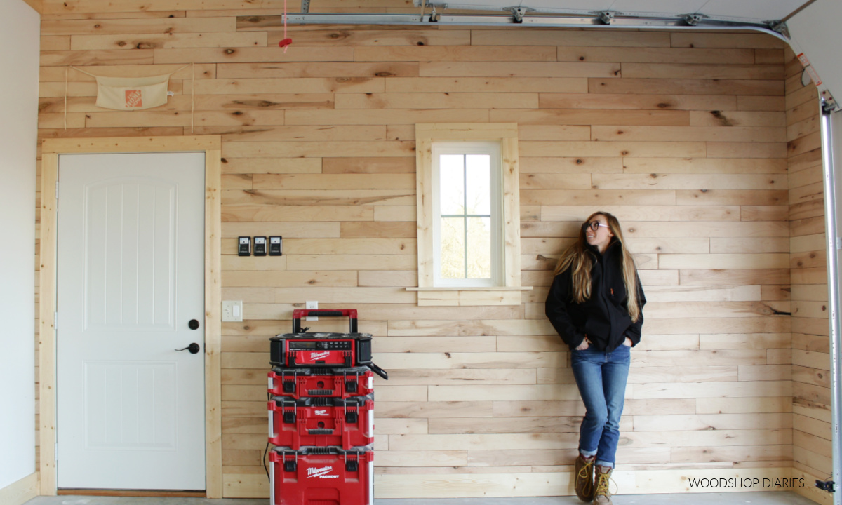 Shara Woodshop Diaries standing in front of wood plank accent wall in workshop