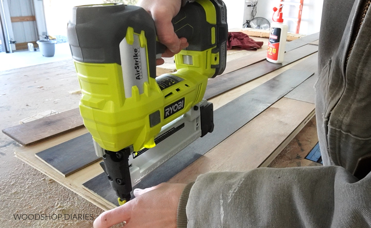 Using a stapler to attach planks to plywood panel board