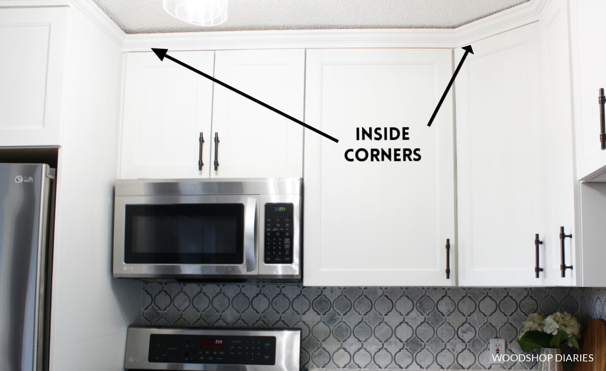 Arrows pointing to inside corners of crown molding on kitchen cabinets