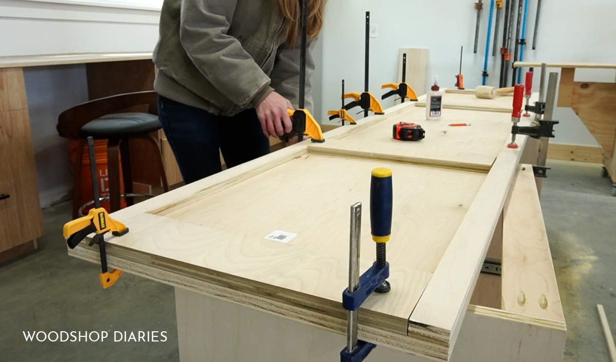 Shara gluing and nailing scraps on bottom side of desk countertop