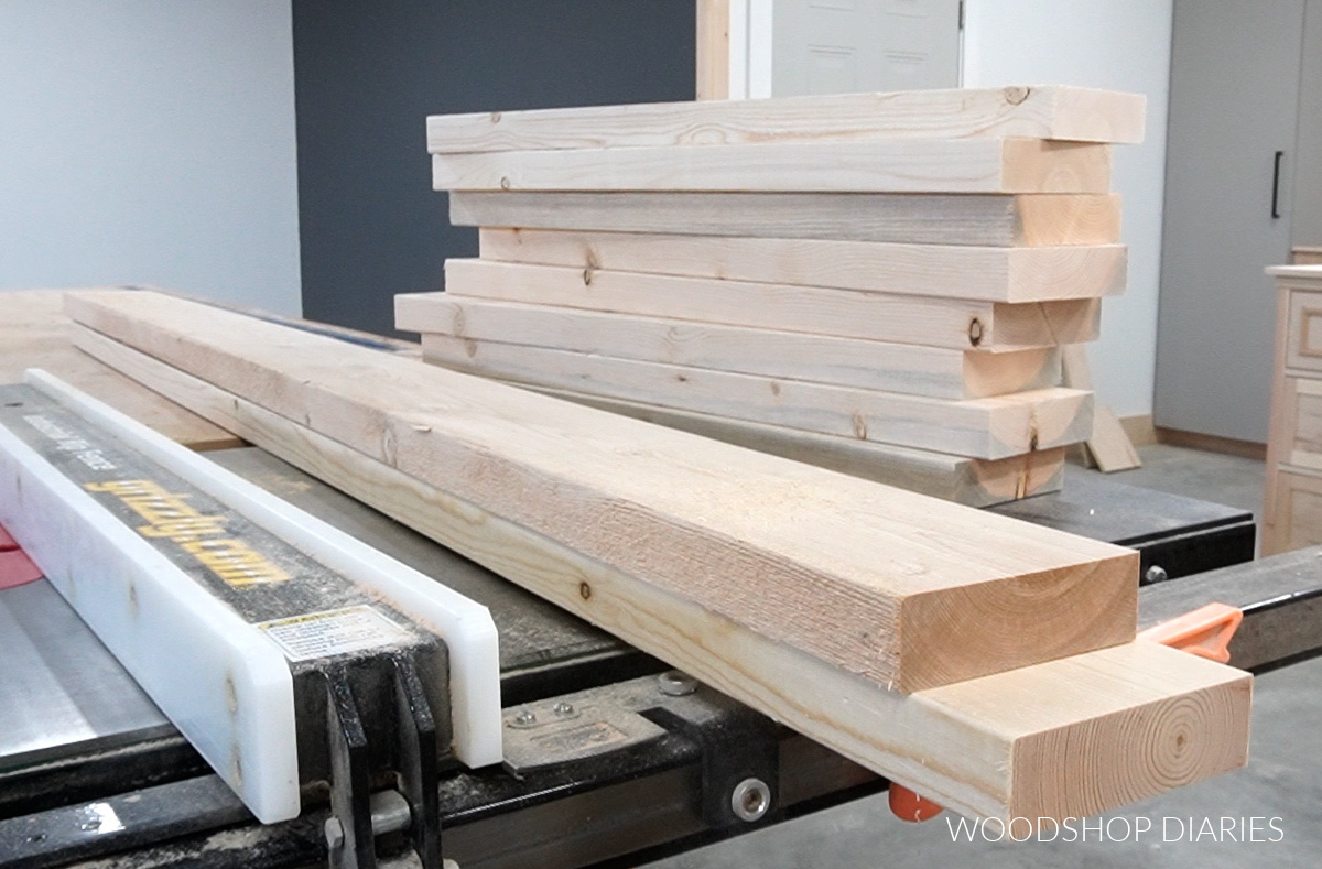 unfinished pine boards stacked on table saw