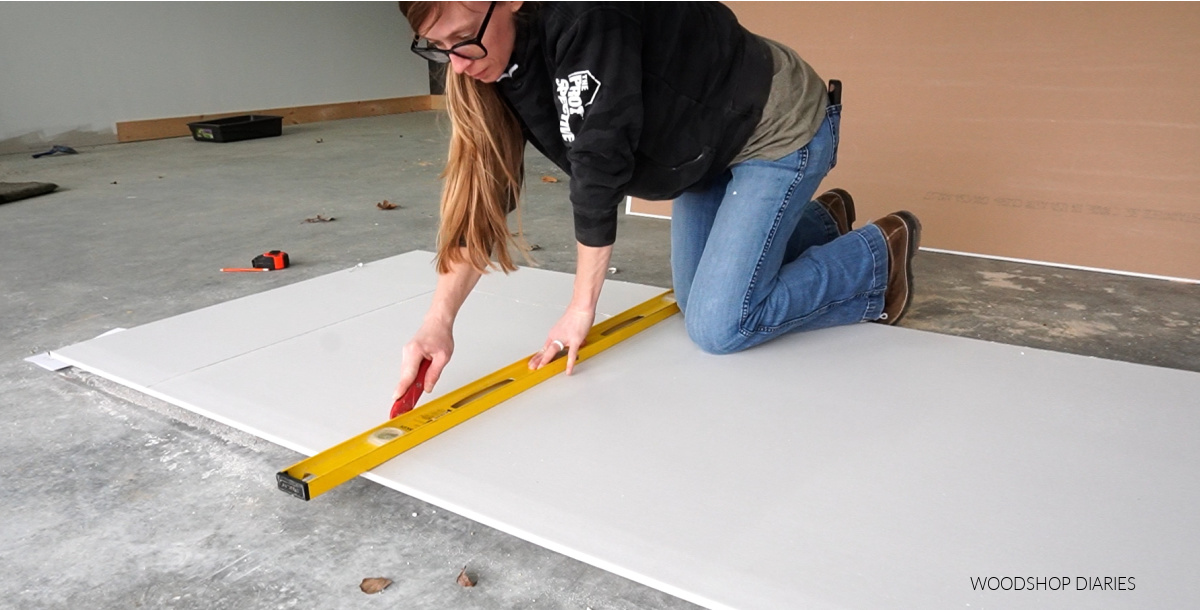 Shara Woodshop Diaries cutting drywall on shop floor