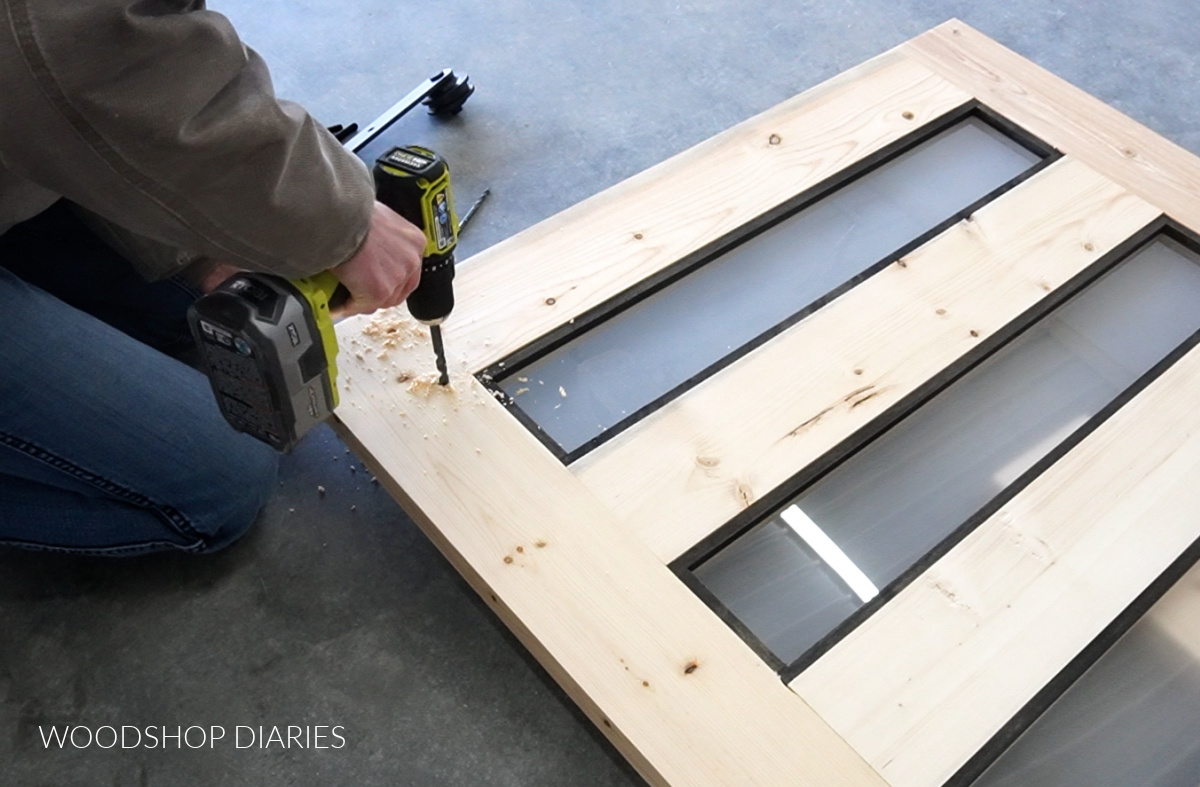 Shara Woodshop Diaries drilling holes in sliding door to install rollers