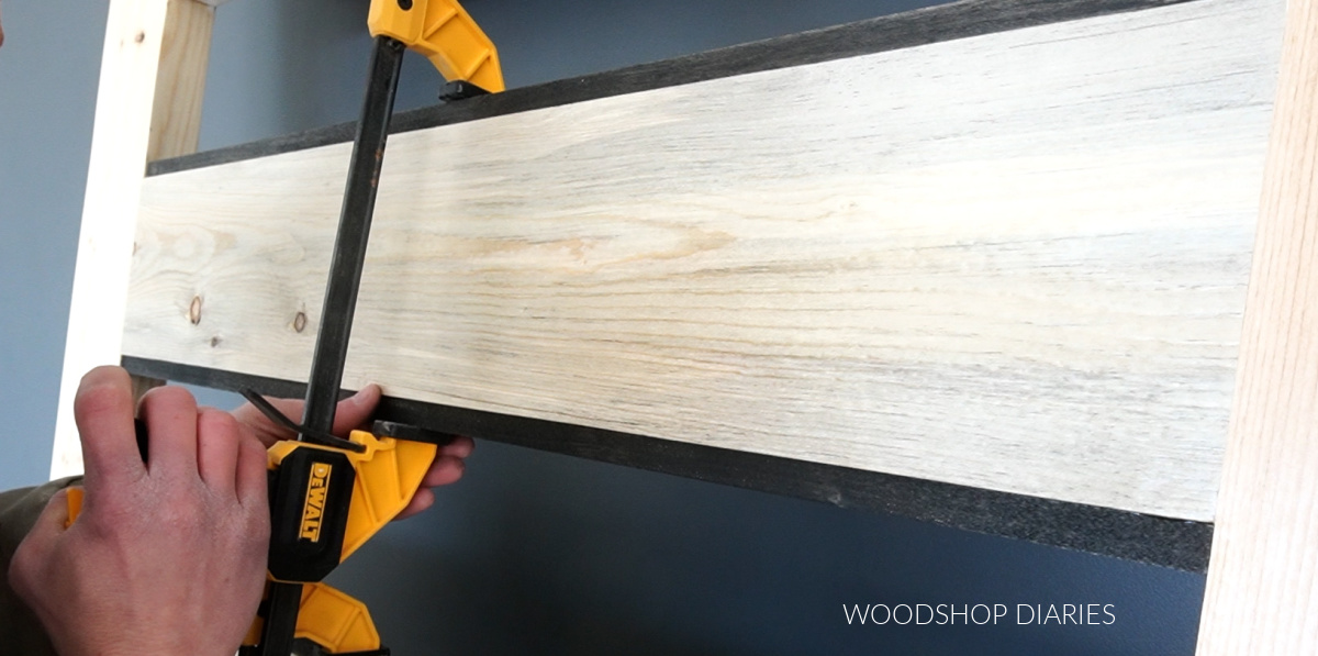 Shara Woodshop Diaries gluing square dowels into openings of DIY sliding door to install glass panels