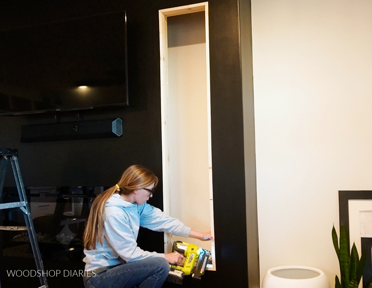 Shara Woodshop Diaries installing corner trim around cubby opening on fireplace wall