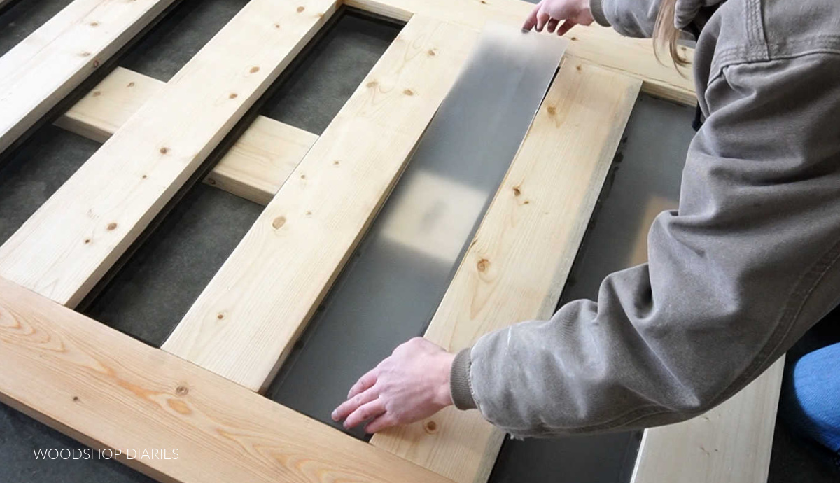 Shara Woodshop Diaries installing plexiglass panels into sliding door