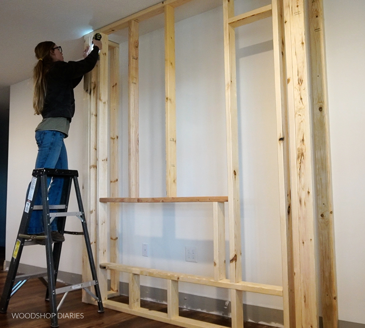 Shara Woodshop Diaries installing front fireplace wall between sides in living room