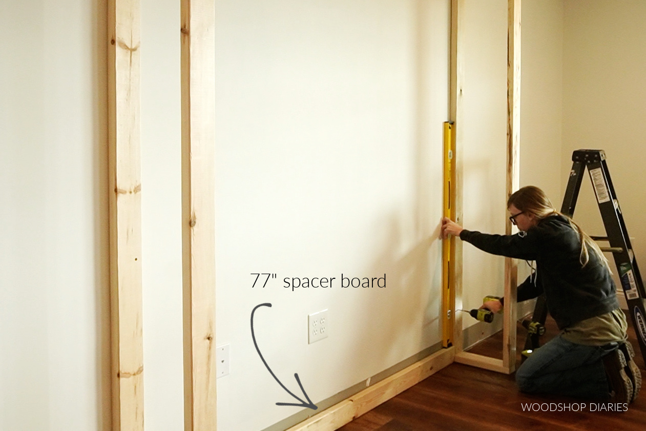 Shara Woodshop Diaries screwing second fireplace side wall into wall studs using spacer block