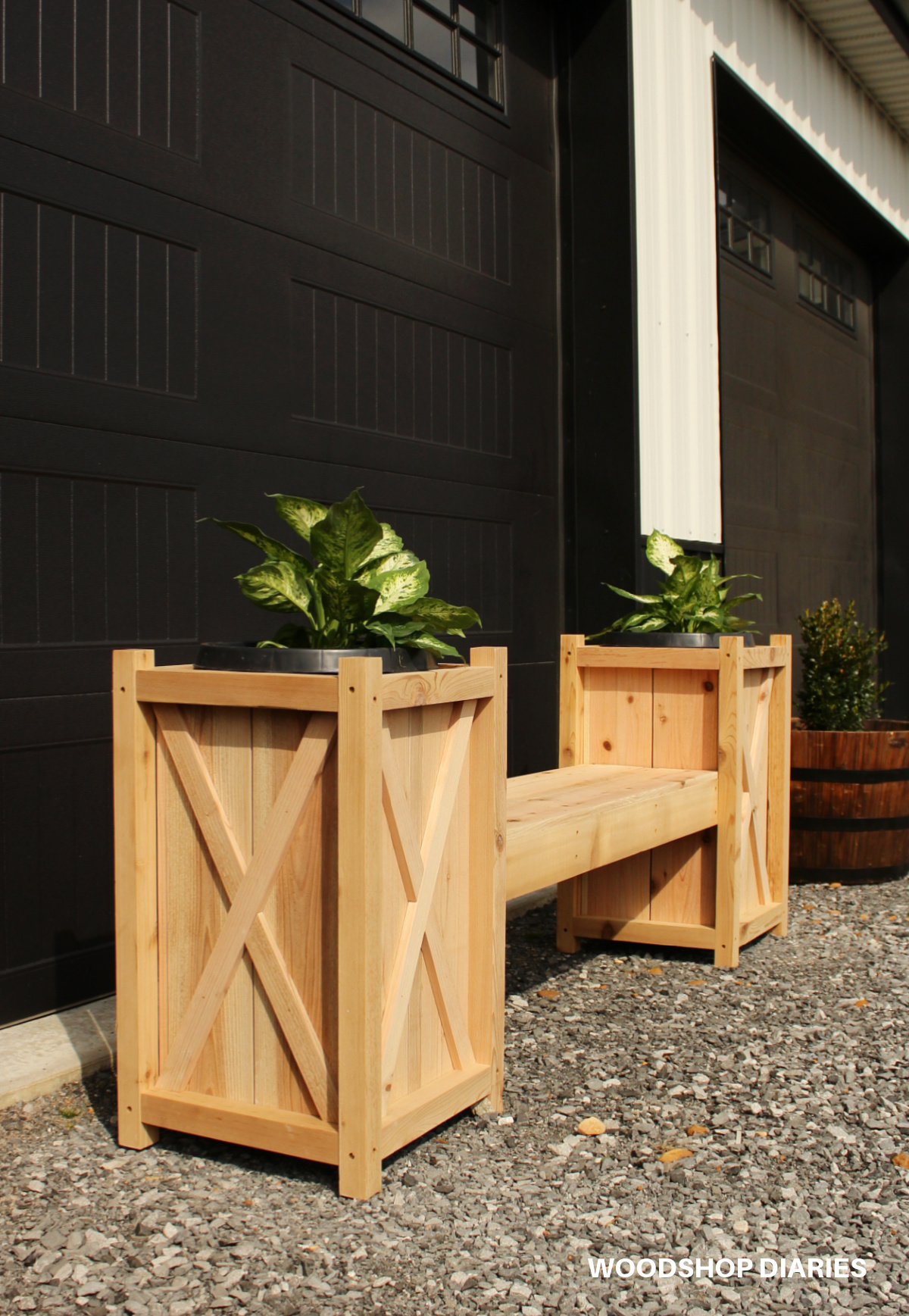 Close up look at DIY wooden planter bench sitting in front of garage door