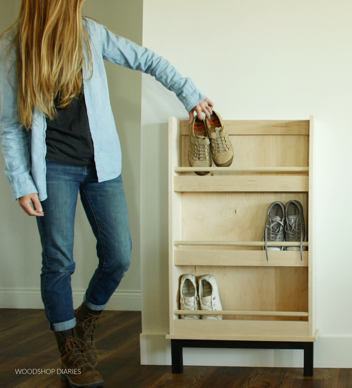 Shara Woodshop Diaries placing shoes in wooden shoe rack