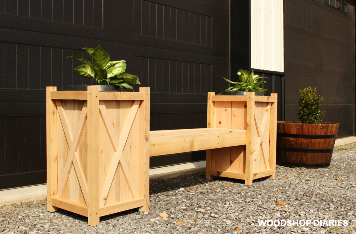 DIY cedar planter bench sitting in front of black garage door