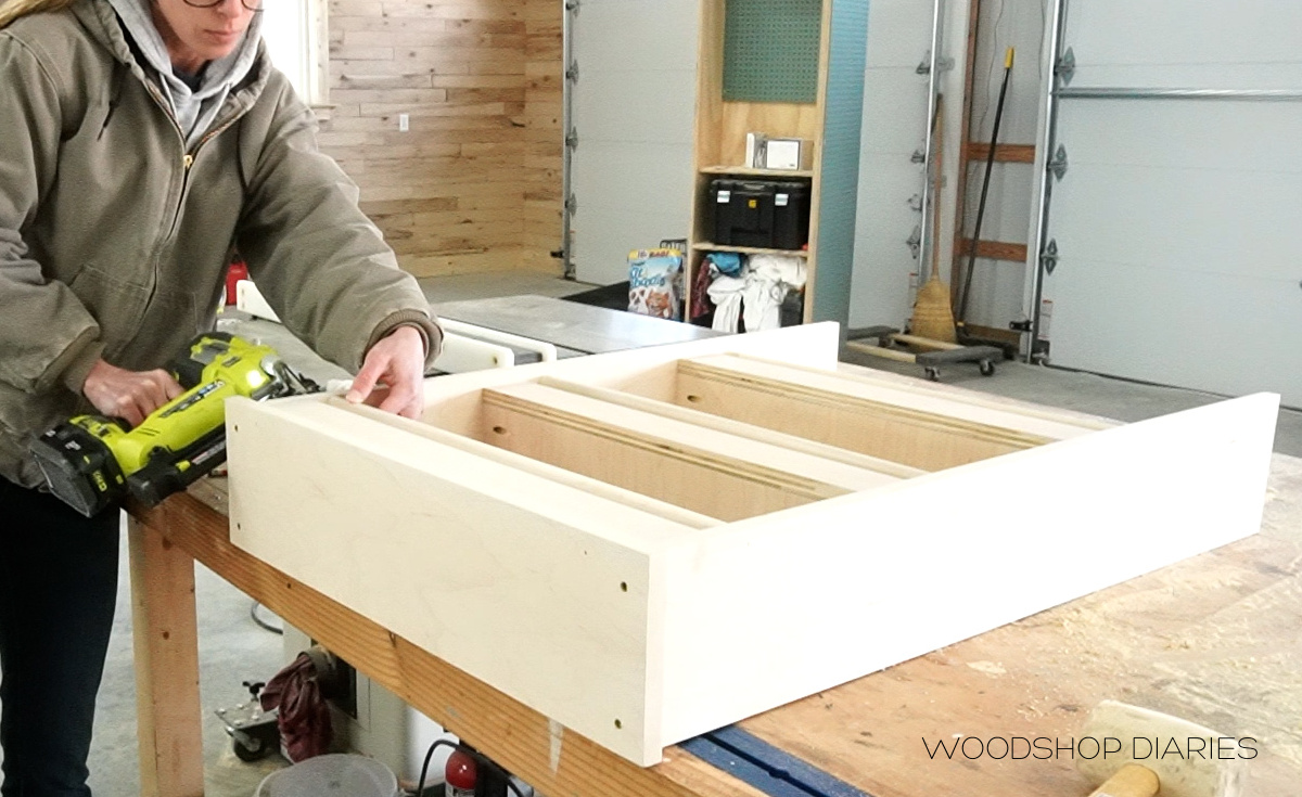 Shara Woodshop Diaries using nail gun to secure dowel rods in bookshelf