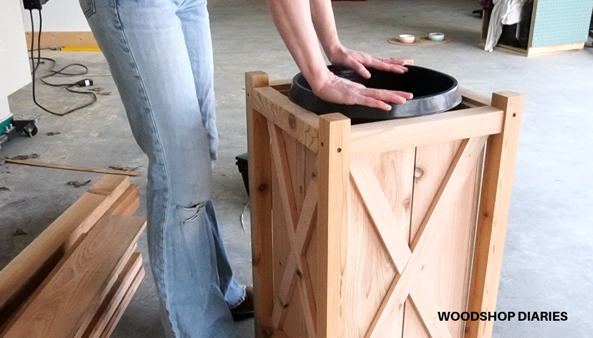 Shara Woodshop Diaries dropping plastic planting bucket into planter box