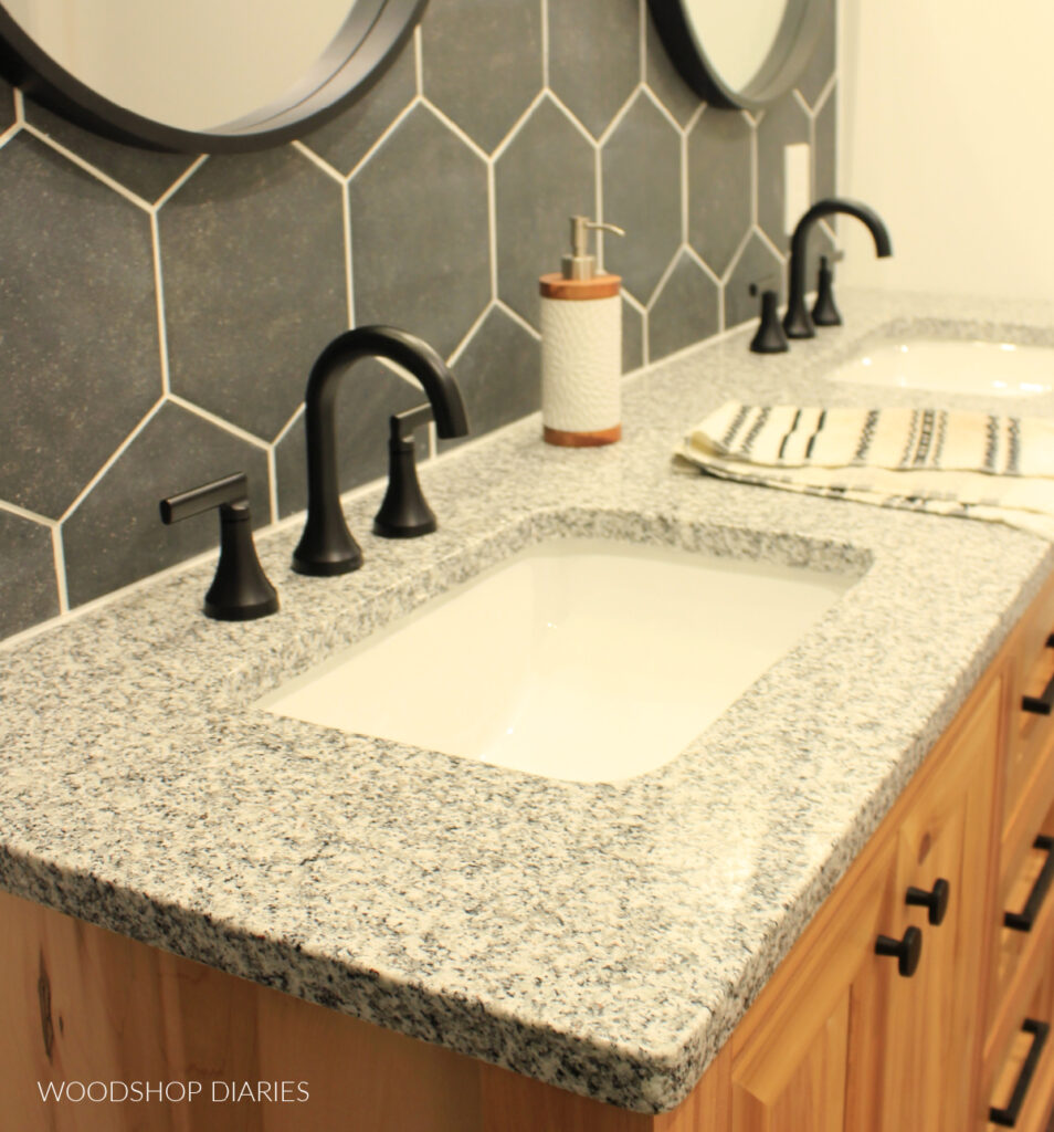 Close of of granite countertop with sinks and faucets in bathroom