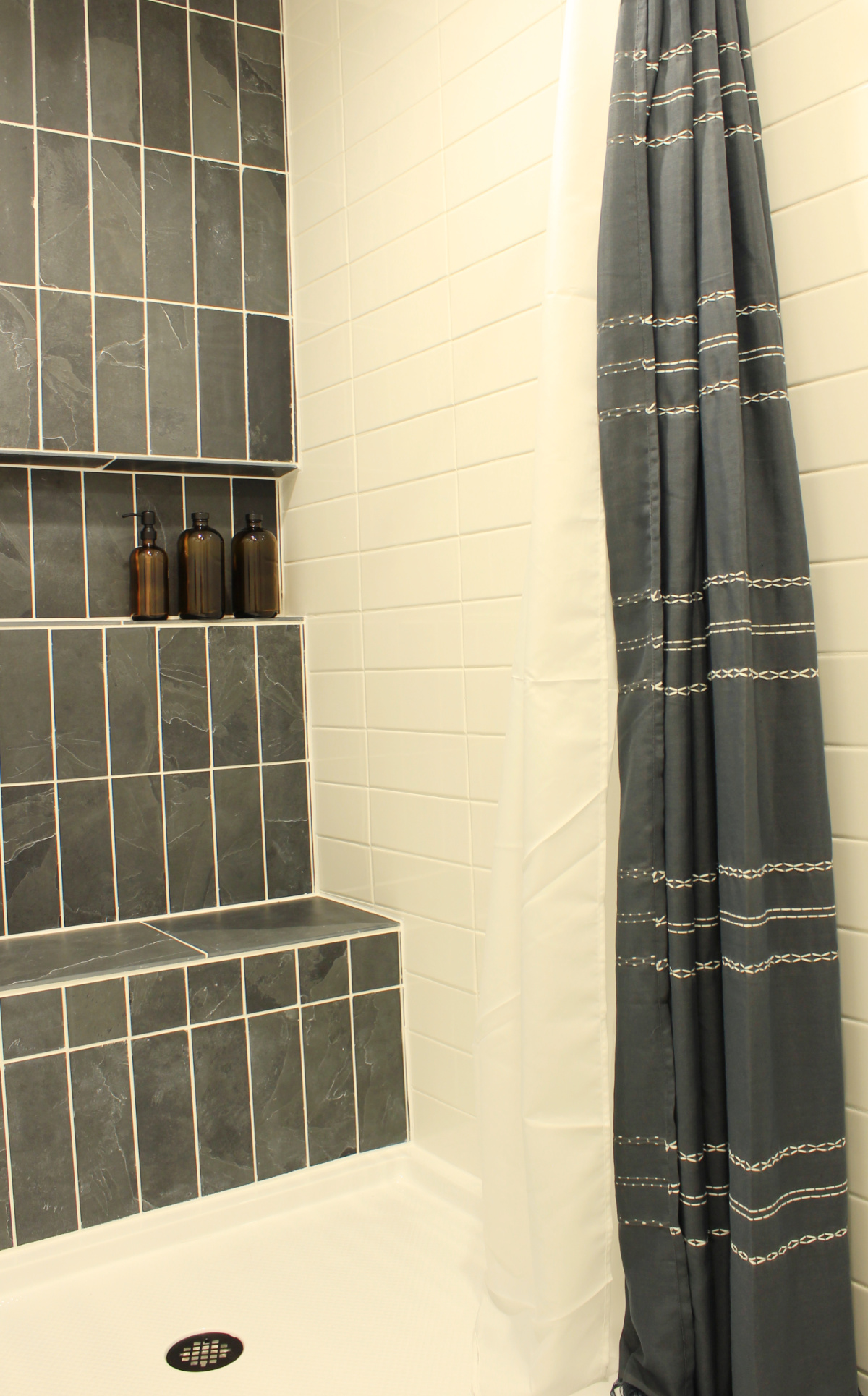 Grey slate and white subway tile shower with acrylic shower pan and charcoal colored shower curtain