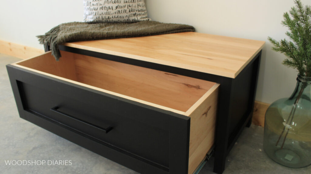 Completed black and wood storage bench with drawer pulled open