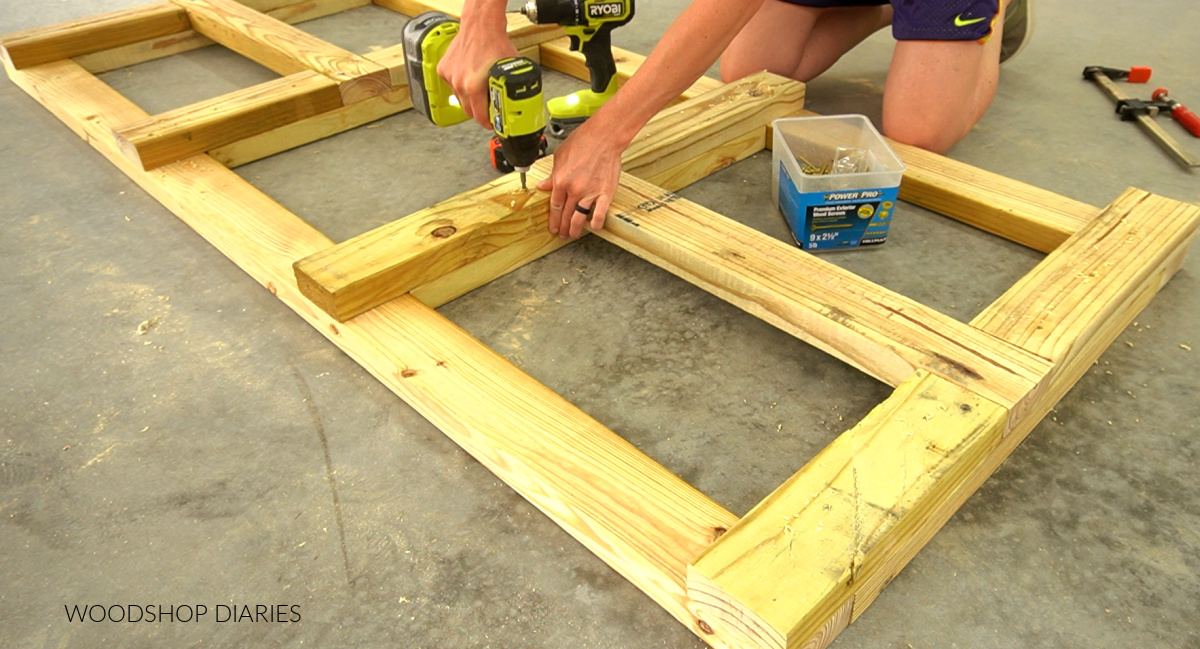 Shara Woodshop Diaries driving screw to assemble grill cart framing on concrete floor