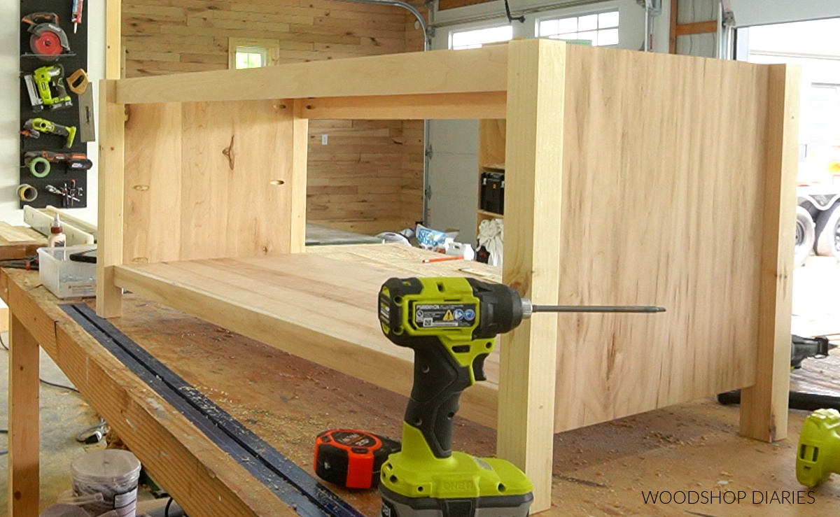 Unfinished storage bench frame sitting on workbench