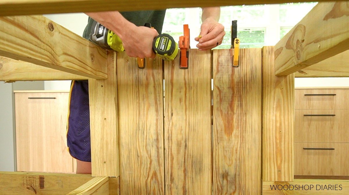 Driving screws to install back panel slats of grill cart cabinet