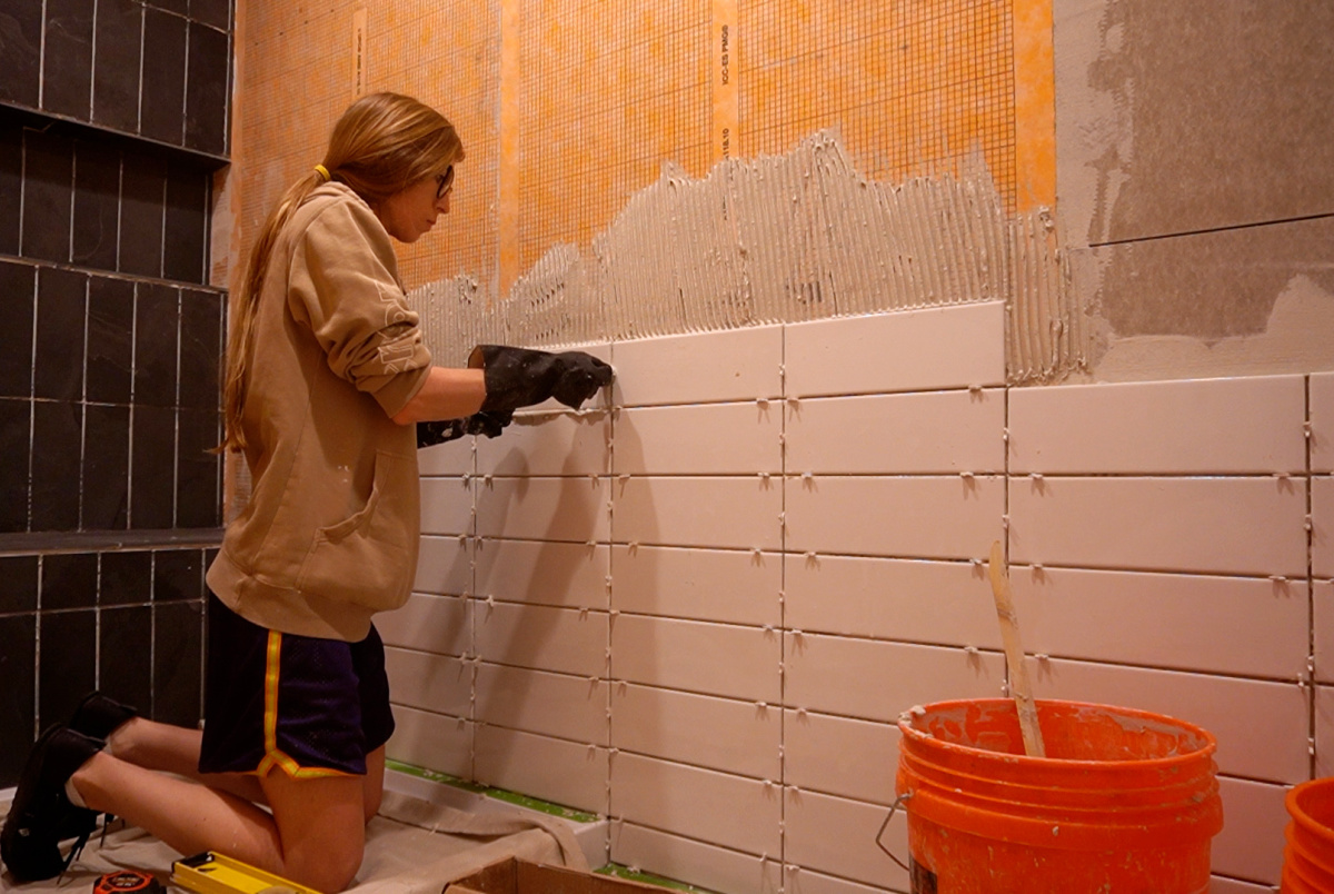 Shara Woodshop Diaries installing subway tile on large shower wall