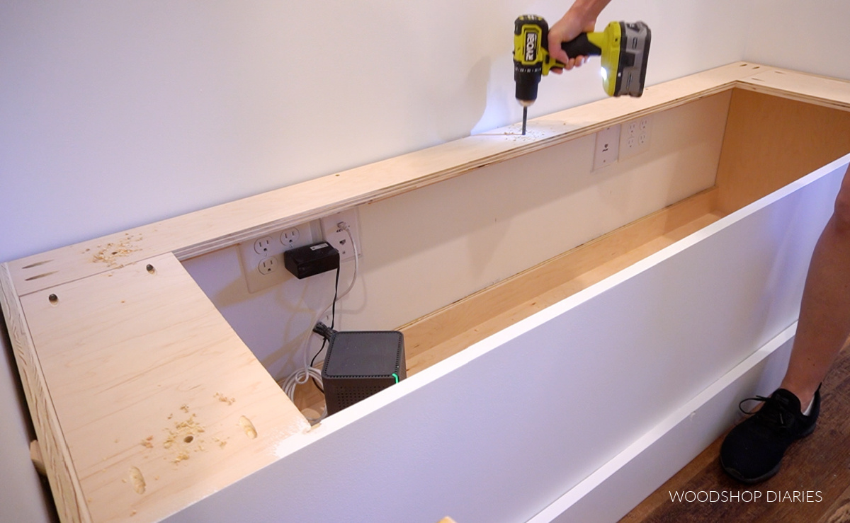 Using a drill to drill holes to install bench top