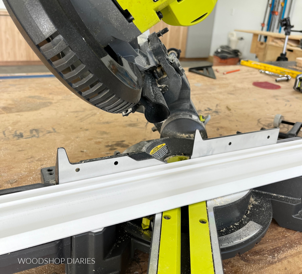 Close up of crown molding placed in miter saw to make an inside corner cut