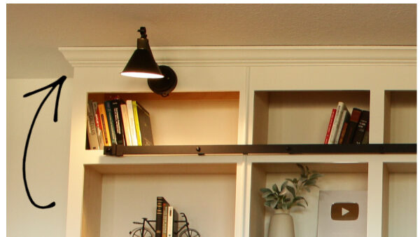 Arrow pointing to outside corner of crown molding on built in library shelves