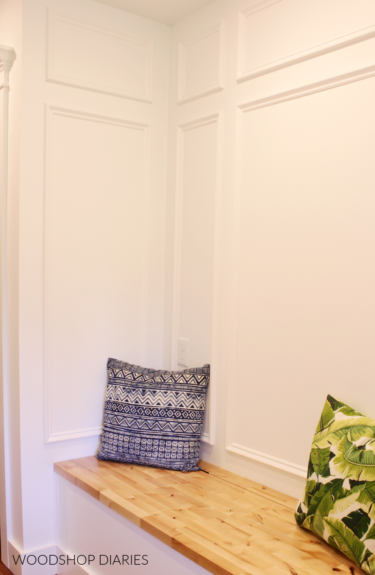 Completed DIY picture frame molding accent wall in built in bench nook painted white