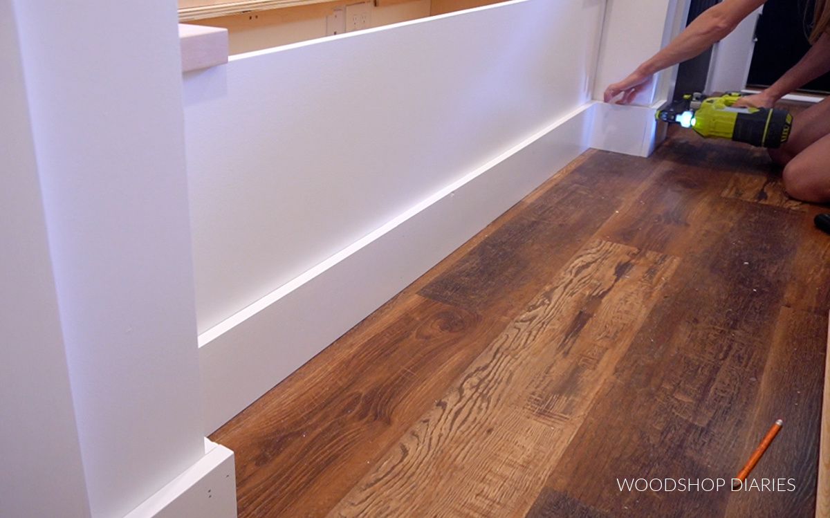 Shara Woodshop Diaries installing baseboards around built in bench in hallway nook