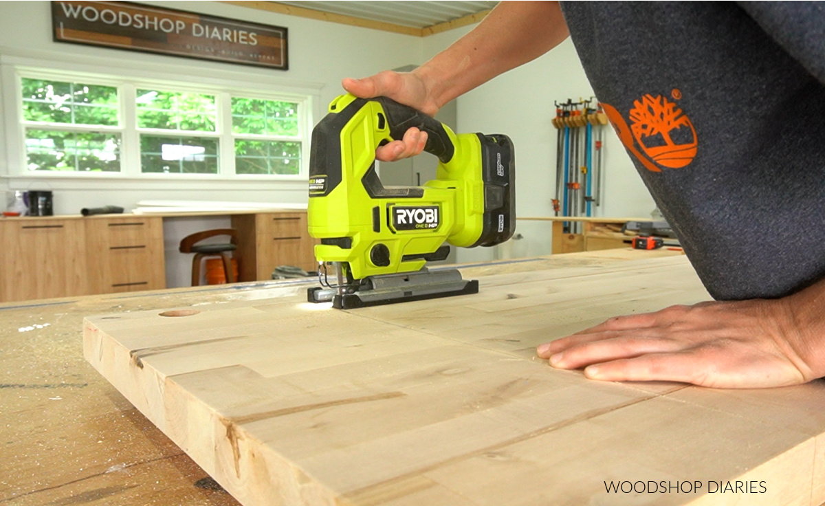 Shara Woodshop Diaries using jig saw to cut corners of flip top section of seat