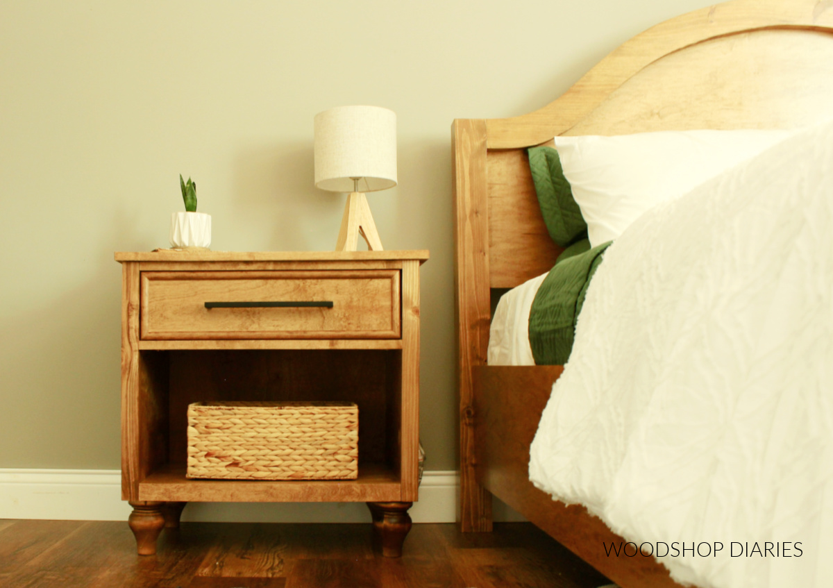 DIY bedside table with single drawer and open storage cubby next to arched headboard bed frame