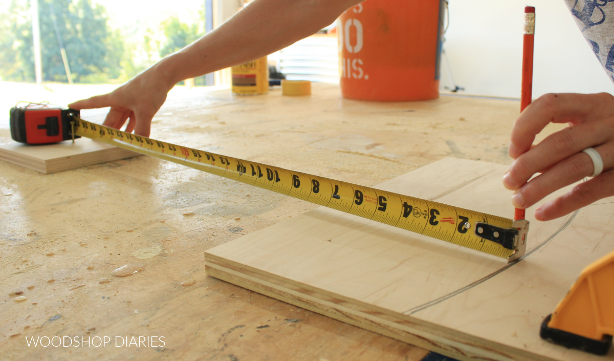 Shara Woodshop Diaries drawing radius onto plywood scrap using tape measure on pivot screw