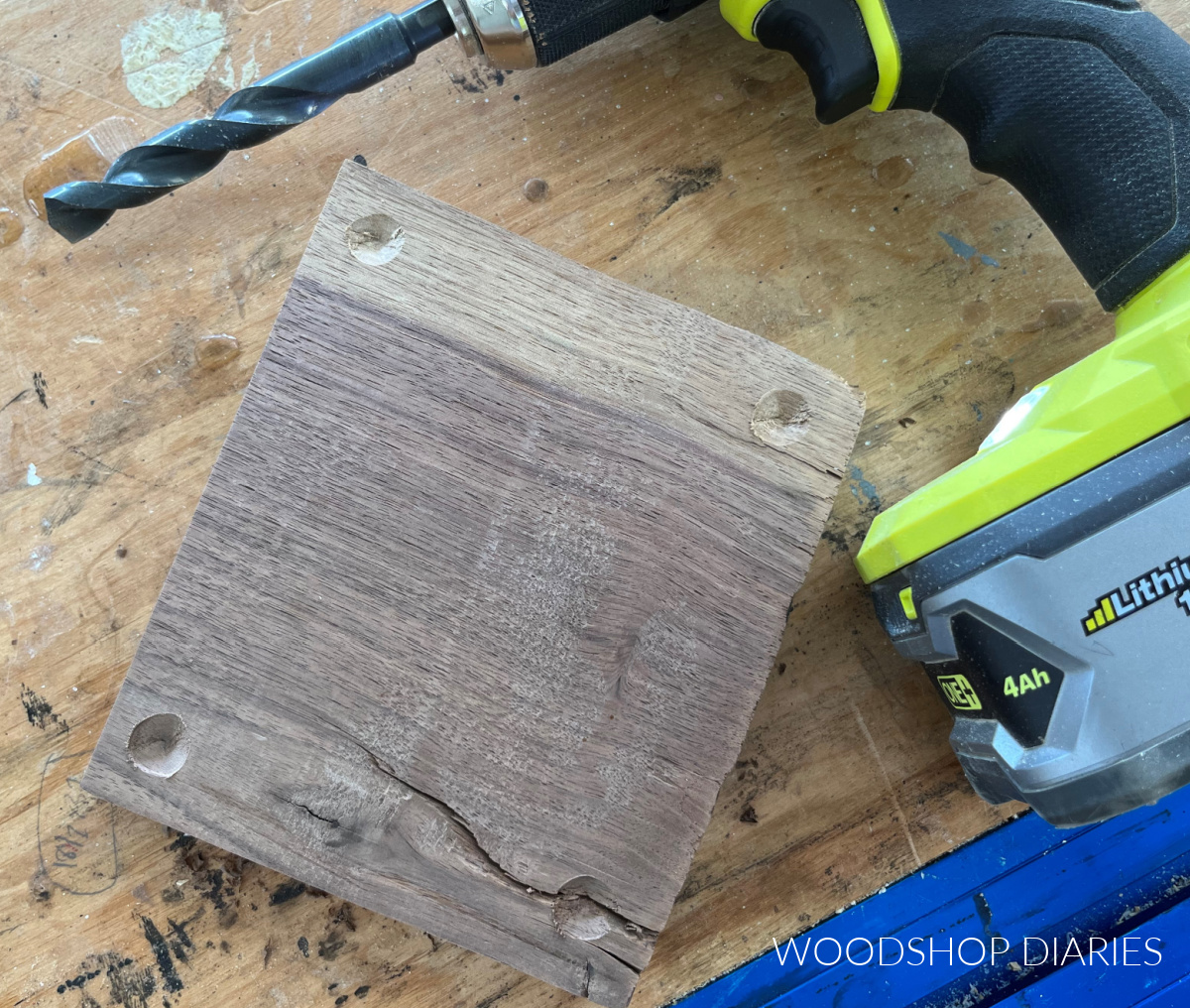 Holes drilled into the bottom side of the wooden footed tray block to install the feet