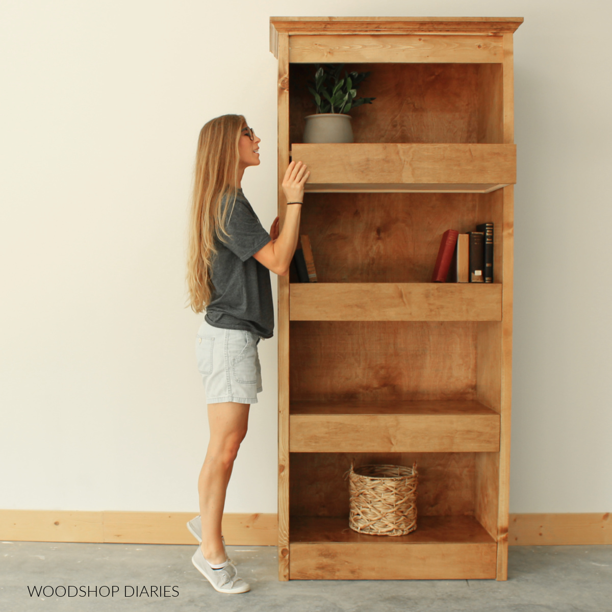 Shara Woodshop Diaries looking inside top drawer of bookshelf with hidden storage