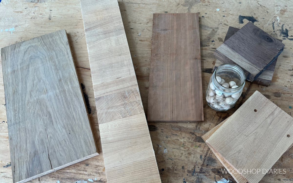 Scrap wood options laid out on workbench with wooden walls in jar to use as feet