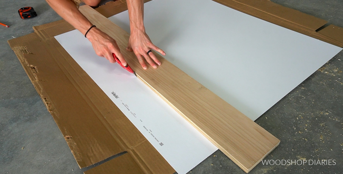 Using a utility knife to cut mat board to size