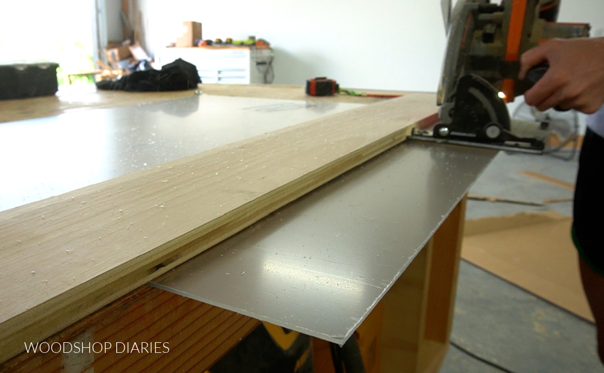 Using a circular saw to cut plexiglass on workbench