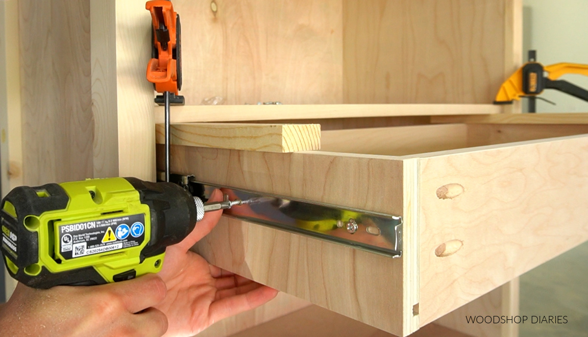 Close up of driving screws to install drawer boxes onto drawer slides in bookshelf cabinet