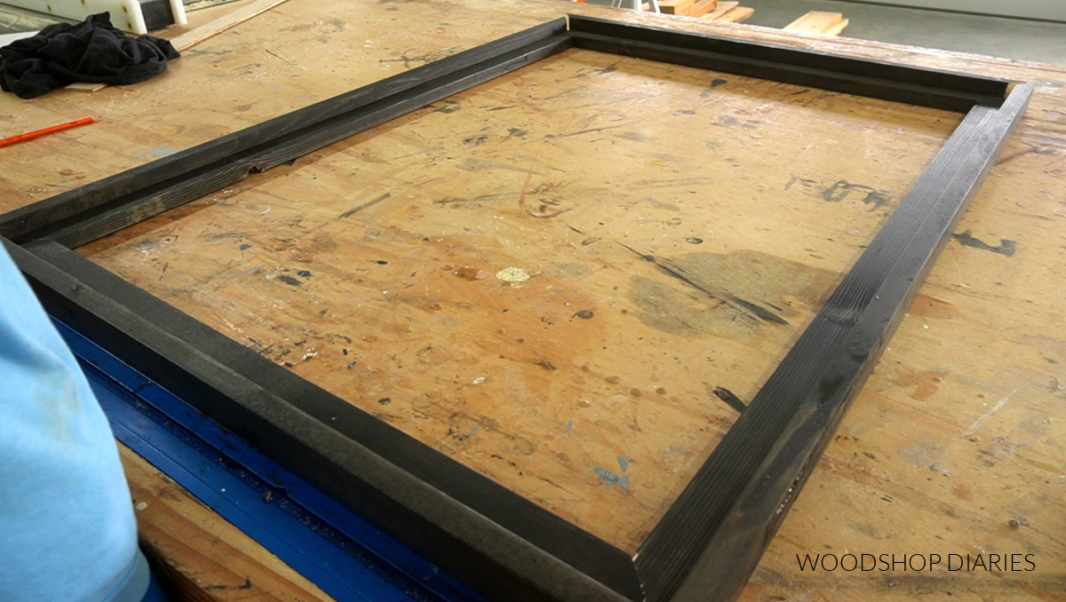 outside frame pieces cut to fit around inside picture frame laid out on workbench