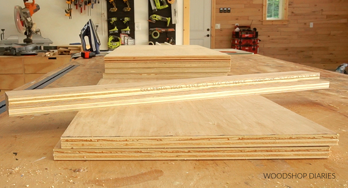 Plywood pieces cut for bookshelf cabinet sitting on workbench