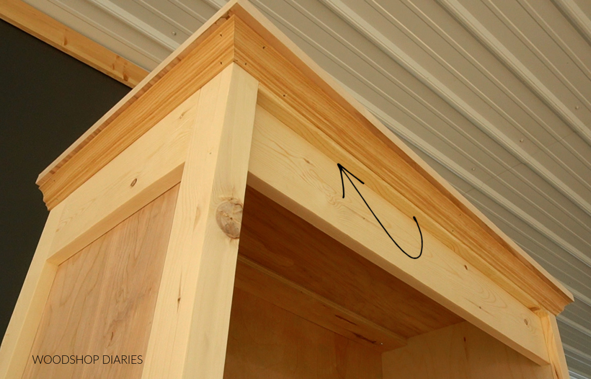 Close up showing spacer block added on front of bookshelf between trim and crown molding