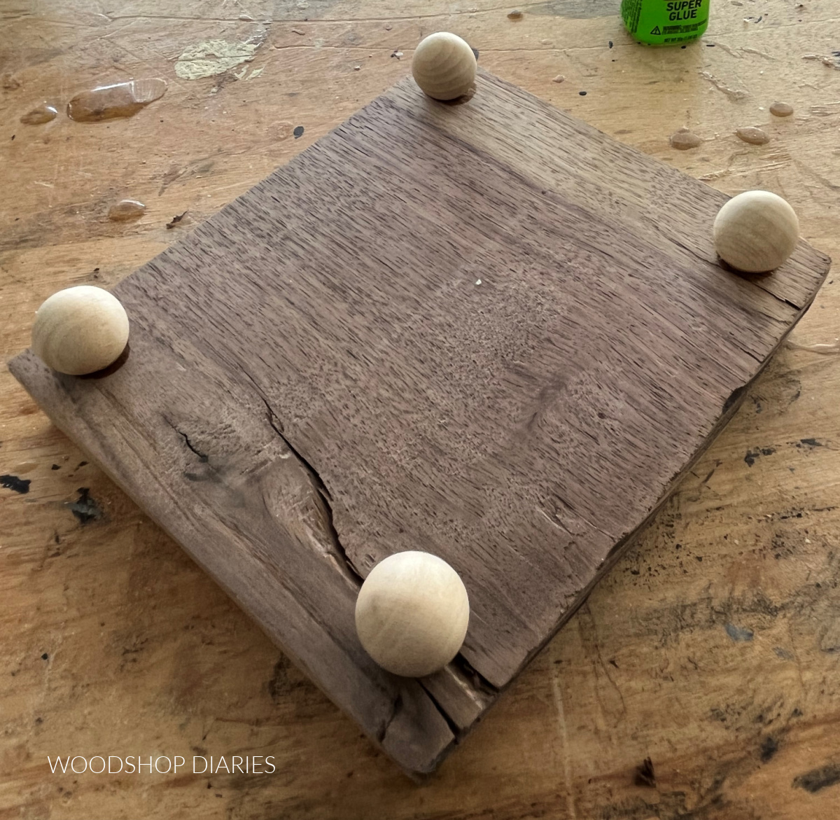 Wooden balls glued on bottom side of wooden tray with feet