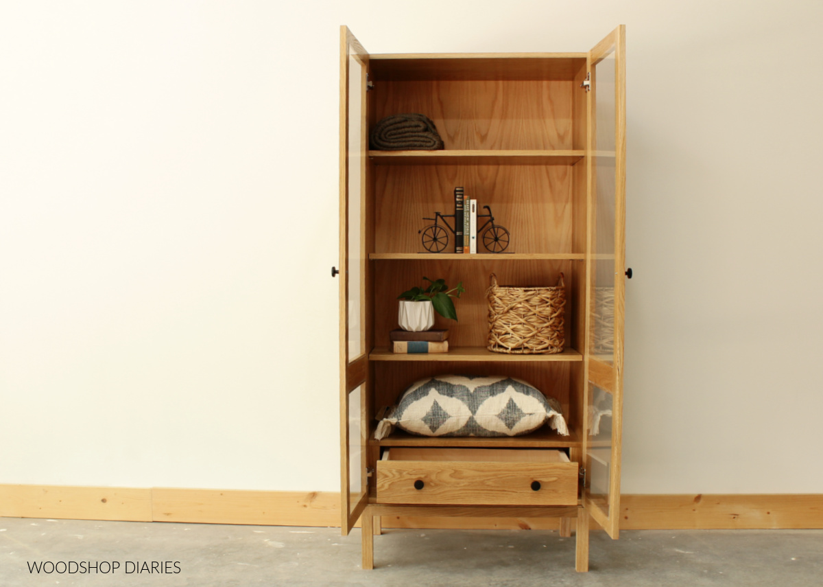 Display cabinet with open doors and drawer