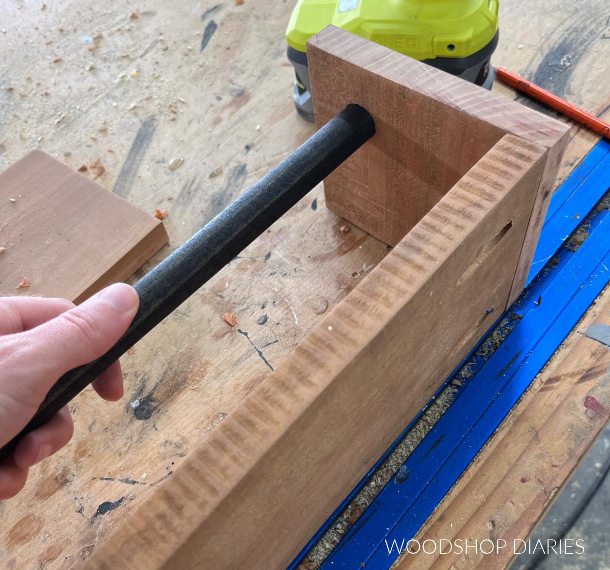 Inserting dowel rod into hole on sides of shelf