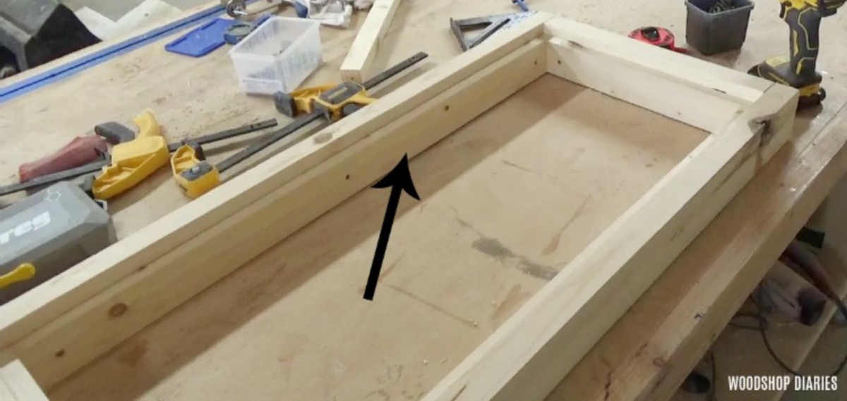 image of frame with 1x3 boards lining the inside sitting on workbench table in workshop