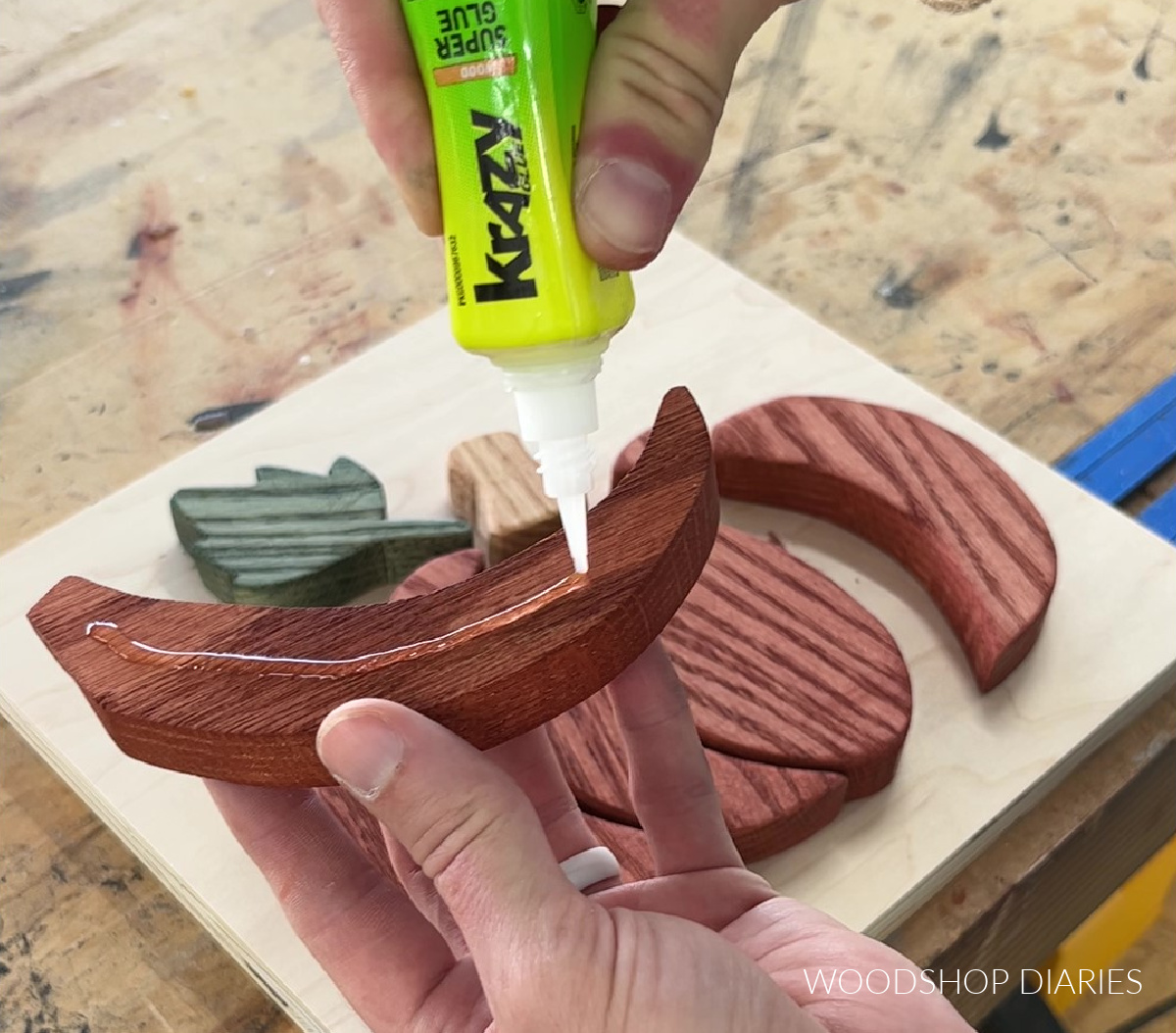 Applying Krazy Glue Fast Dry Wood Glue to pumpkin pieces to glue wooden sign together